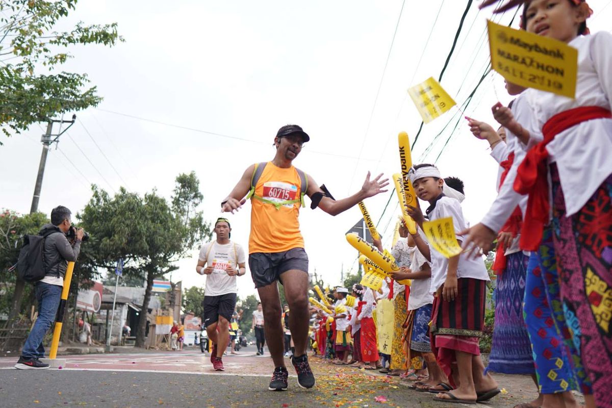 Warga Kabupaten Gianyar menyambut hangat para peserta lomba lari Maybank Marathon Bali 2019, Minggu (8/9/2019). Total ada lebih dari 11.600 peserta dari 50 negara yang turut serta dalam lomba lari internasional tahunan yang digelar untuk kedelapan kalinya ini.