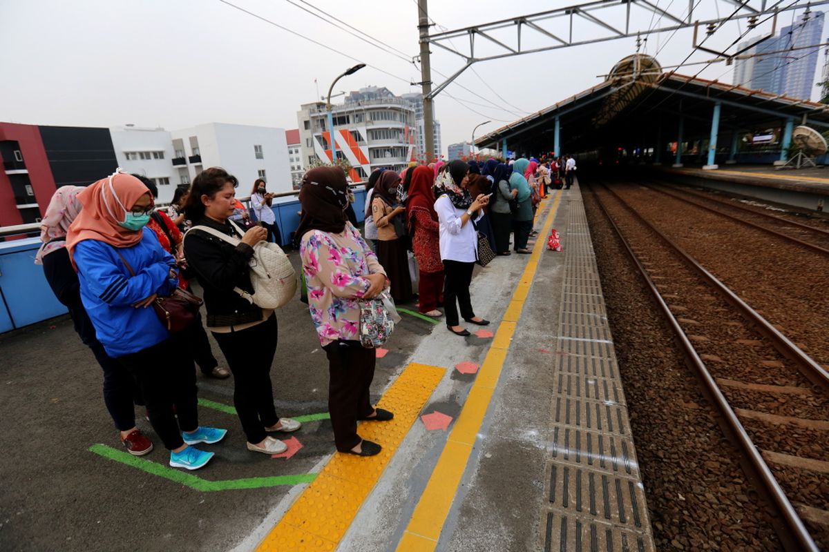 Sejumlah penumpang kereta listrik (KRL) Jabodetabek menunggu di garis batas antrean berwarna hijau di Stasiun Juanda, Jakarta Pusat, Rabu (9/8/2017). Garis batas antrean ini dibuat agar arus keluar masuk penumpang lebih teratur dan diharapkan dapat menghindari aksi saling mendorong sesama penumpang KRL.