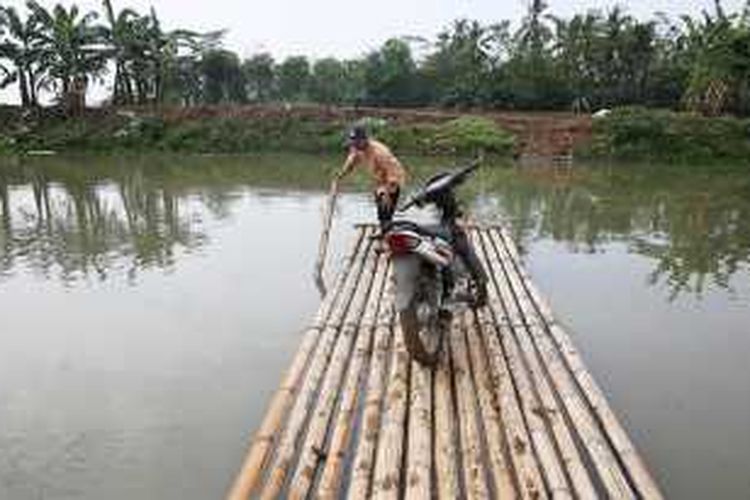 Murtani, kepala sekolah SD Sorongan 2, Kecamatan Cibaliung, Kabupaten Pandeglang, Banten, menaiki rakit menyeberangi sungai untuk menuju sekolah, Jumat (20/11/2015). Lokasi sekolah yang sulit diakses memuat guru harus berjuang untuk menuju sekolah.