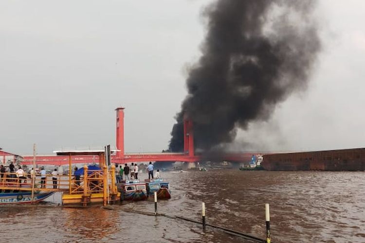 Jembatan Ampera diselimuti asap hitam akibat meledaknya satu perahu jukung di perairan sungai Musi Palembang, Sumatera Selatan usai mengisi BBM, Kamis (20/12/2018).