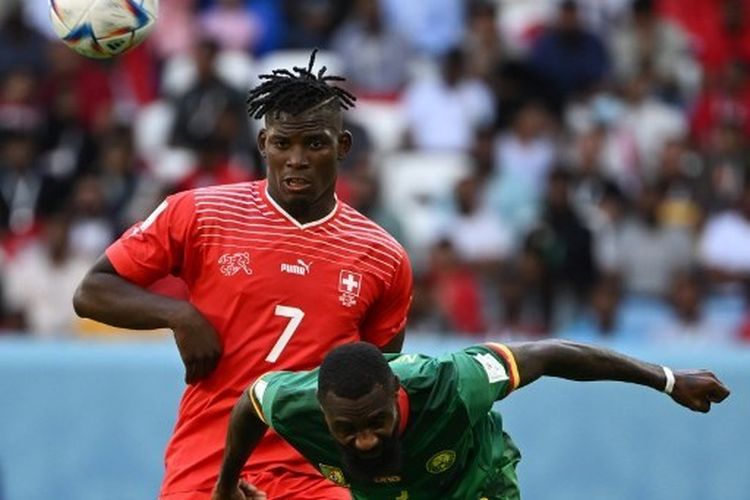 Penyerang timnas Swiss, Breel Embolo (kiri), berebut bola dengan pemain belakang timnas Kamerun, Nicolas Nkoulou, pada pertandingan Grup G Piala Dunia 2022.  Laga Swiss vs Kamerun tersebut dilangsungkan di Stadion Al Janoub di kota Al Wakrah pada Kamis (24/11/2022) sore WIB.