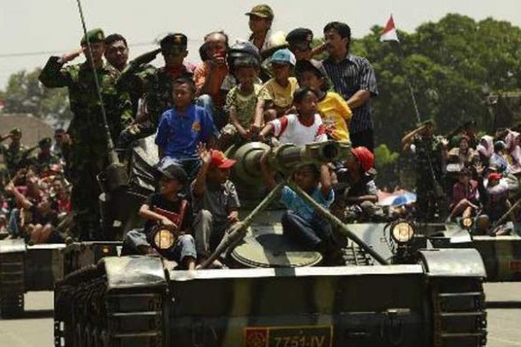 Warga mengikuti defile pasukan dengan menaiki tank saat peringatan HUT ke-67 Tentara Nasional Indonesia di lapangan Jenderal Soedirman, Ambarawa, Kabupaten Semarang, Jawa Tengah, Jumat (5/10/2012).  