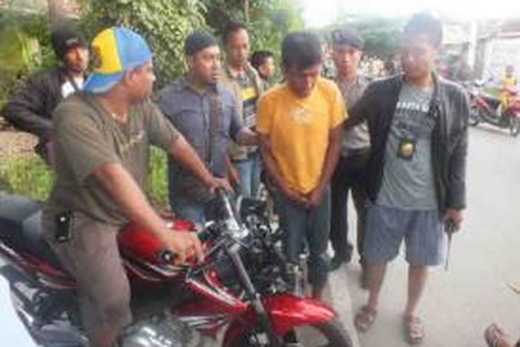 Rahman Wahidin (31) (baju kuning) sedang diapit aparat Polres Kota Kupang