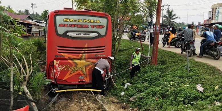 Polisi sedang memasang garis pengaman di lokasi kecelakaan bus Simpati Star di Desa Buket Pala, Kecamatan Idi Rayeuk, Aceh Timur, Minggu (30/10/2016)