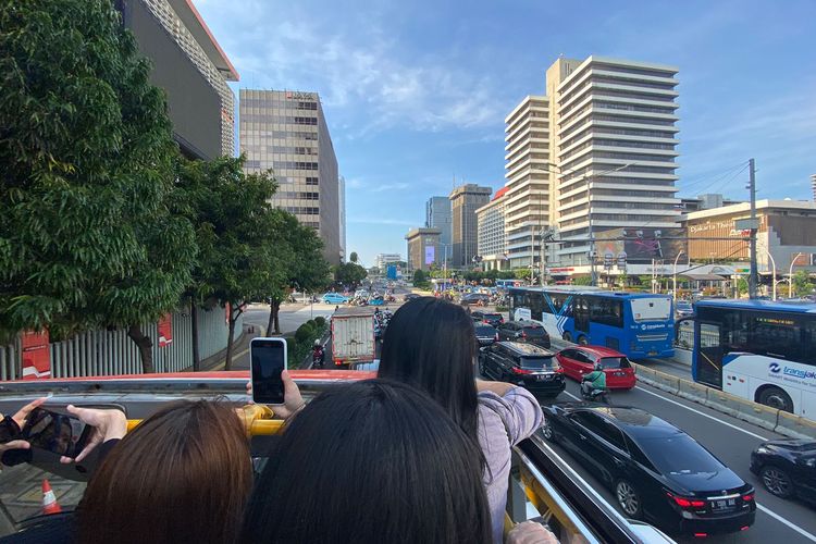 Penampakan gedung-gedung tinggi yang dilihat dari bus wisata Transjakarta atap terbuka. 