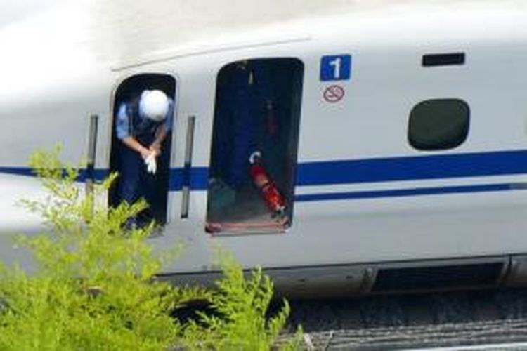 Petugas memeriksa gerbong kereta api cepat Shinkansen yang dihentikan mendadak di Odawara, Tokyo bagian timur, Selasa (30/6/2015) karena ada penumpang yang membakar diri.