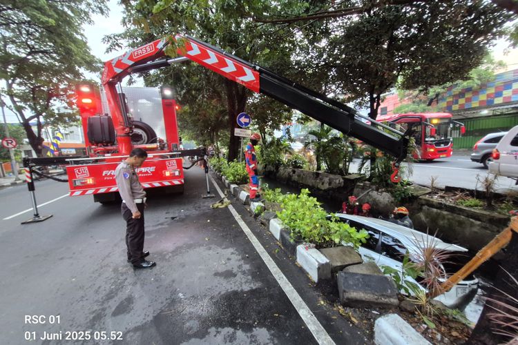 Petugas DPKP Surabaya saat mengevakuasi mobil tercebur ke Sungai Nginden, Minggu (6/1/2025)