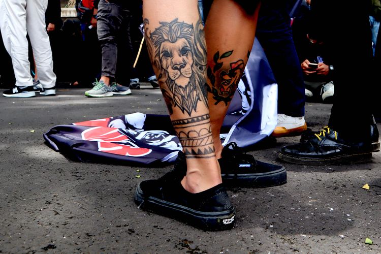 Tato seorang suporter Arema FC, Aremania saat melakukan aksi damai menuntut penegakan hukum yang adil terkait Tragedi Kanjuruhan yang menelan 133 korban meninggal di Kota Malang, Kamis (20/10/2022) pagi.