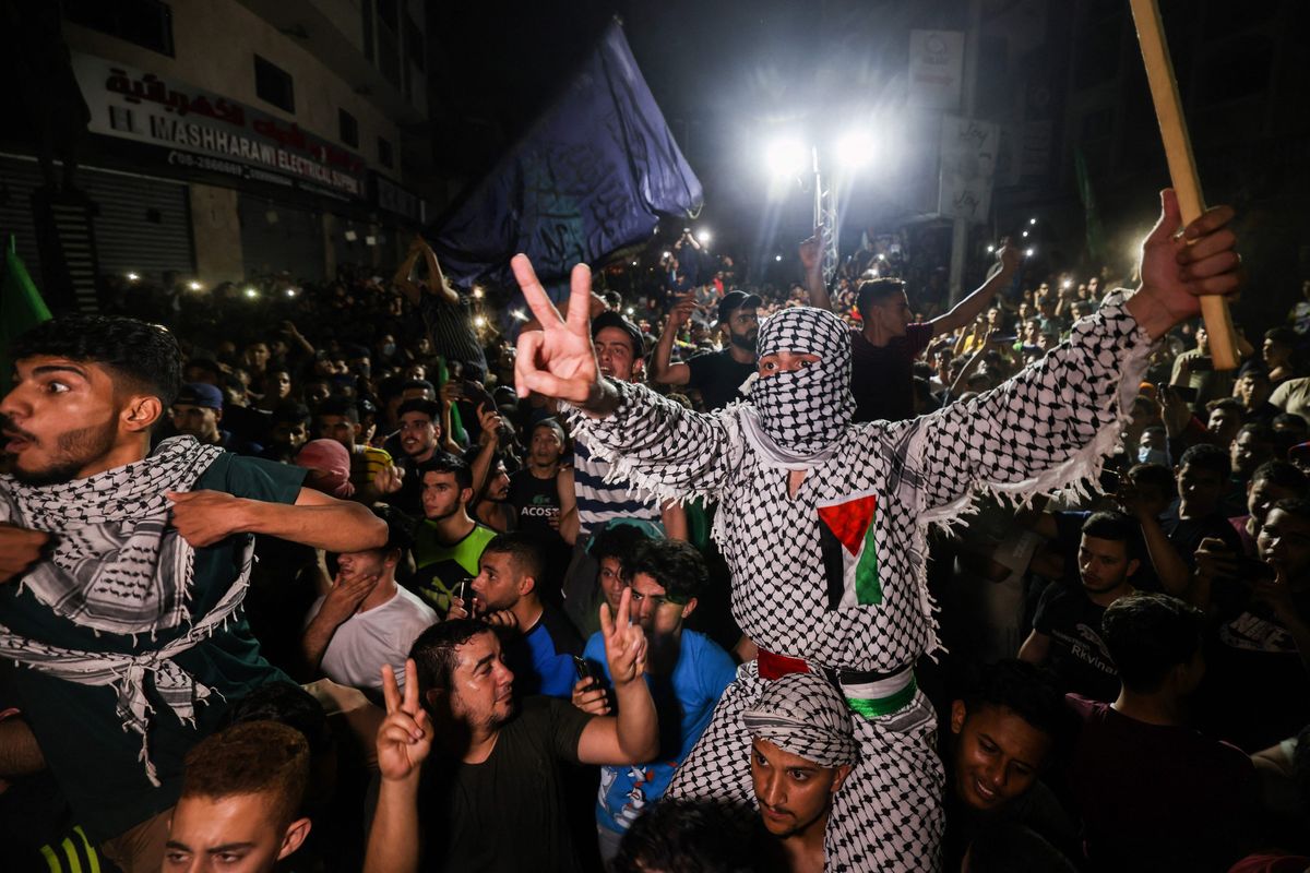 Palestinians celebrate in the streets following a cease-fire brokered by Egypt between Israel and the ruling Islamist movement Hamas in the Gaza Strip, on May 21, 2021, in Gaza City.