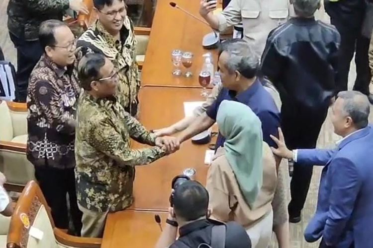 Momen Menko Polhukam sekaligus Ketua Komite TPPU Mahfud MD bersalaman dengan anggota Komisi III DPR Benny K Harman usai rapat diwarnai debat panas membahas transaksi janggal Rp 349 triliun, di Kompleks Parlemen Senayan, Jakarta, Rabu (29/3/2023) malam.