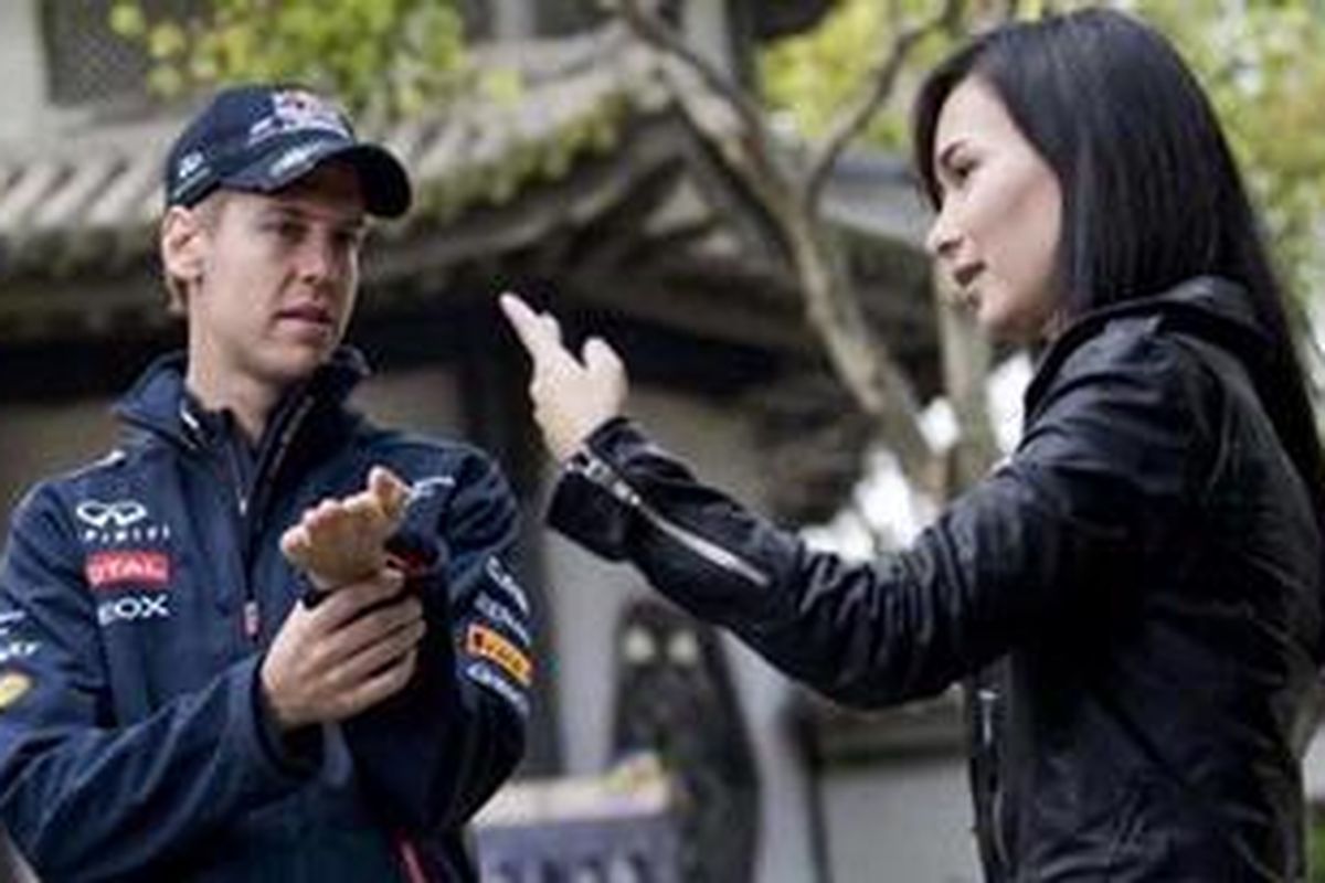 Pebalap Red Bull Racing, Sebastian Vettel (kiri), sedang memperhatikan penjelasan dari aktris China, Celina Jade, dalam pembuatan film Kung Fu Vettel: Drive of the Dragon