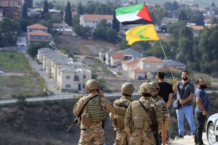 Bendera Hizbullah dan Palestina dikibarkan di perbatasan Lebanon-Israel di Lebanon selatan.