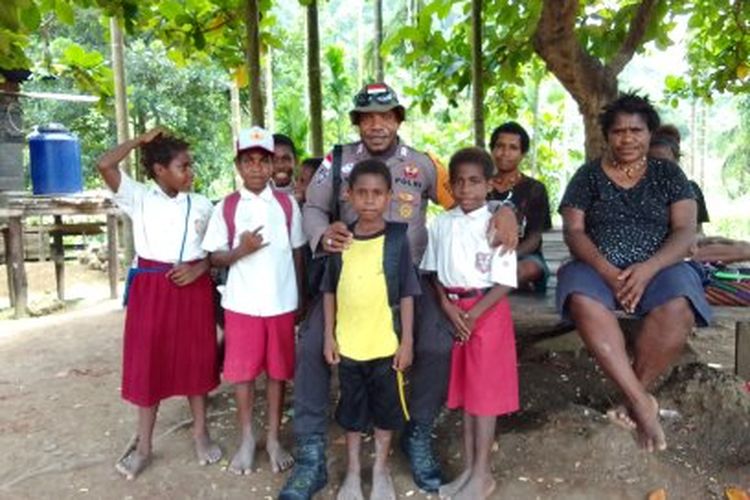 Bripka Batias Yikwa (tengah pakai seragam polisi), saat bersama-sama dengan anak-anak sekolah dari Dusun Baburia Gunung dan ibu-ibu di Dusun Baburia Gunung, Kampung Baburia, Distrik Arso Barat, Kabupaten Keerom, Papua, belum lama ini.