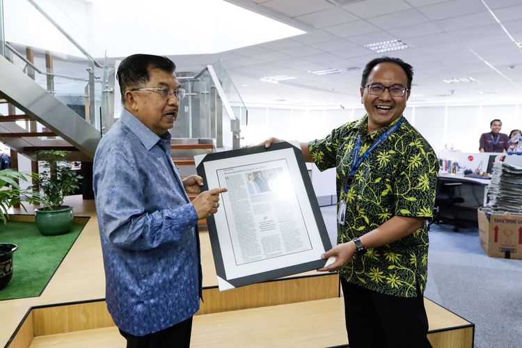 Wakil Presiden ke-10 dan ke-12 RI, Jusuf Kalla mendapat cinderamata dari Direktur National News KG Media, Budiman Tanuredjo saat mengunjungi kantor redaksi Kompas di Menara Kompas, Jakarta, Senin (21/10/2019).