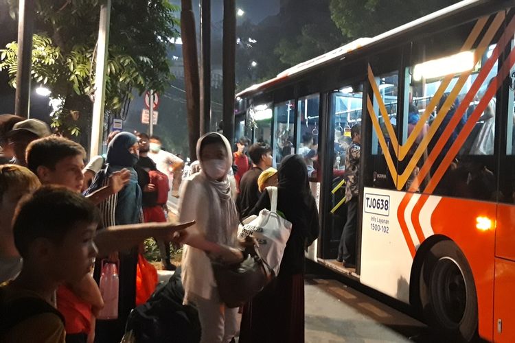Pencari suaka mengantre untuk masuk ke dalam bus transjakarta kembali ke Kalideres, Jakarta Barat, Kamis (10/10/2019) malam.