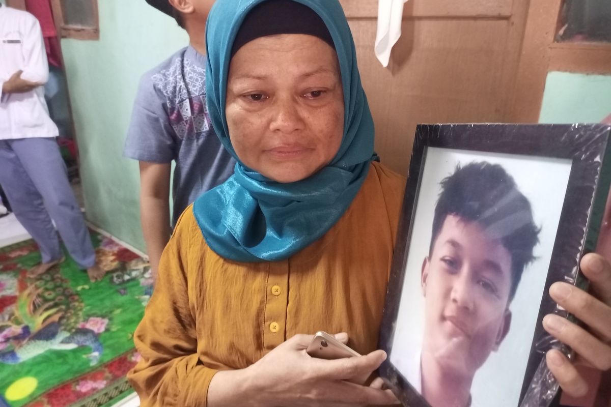 Keluarga sedang memegang foto Arya Saputra (16), korban pembacokan di lampu merah Simpang Pomad saat ditemui di rumahnya, Desa Cijujung, Kecamatan Sukaraja, Kabupaten Bogor, Jawa Barat, Senin (13/3/2023).