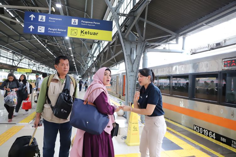 Salah satu petugas KAI saat mengarahkan penumpang di stasiun KAI. 