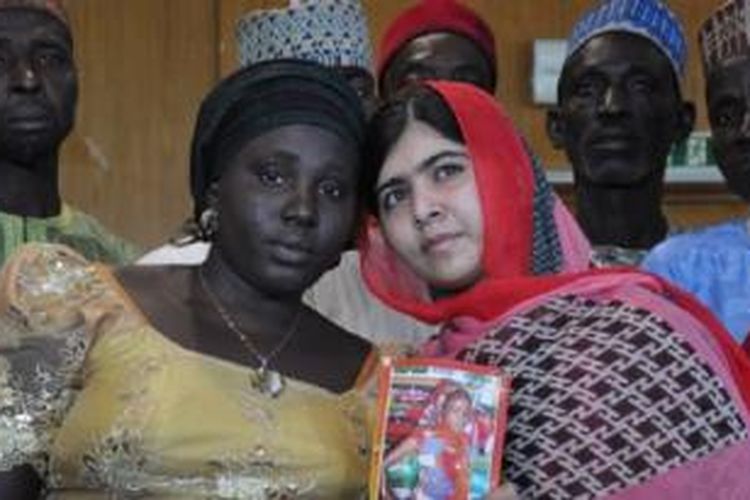 Aktivis Pakistan Malala Yousafzai yang ditembak dan hampir terbunuh oleh Taliban Pakistan karena upayanya menggalakkan pendidikan bagi perempuan dan anak-anak perempuan, memegang foto siswa yang diculik Sarah Samuel bersama ibunya Rebecca Samuel, dalam kunjungan ke Abuja, Nigeria, 13 Juli 2014. 