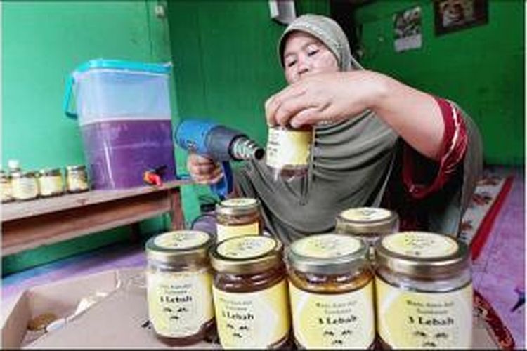 Jueria (39), pedagang madu di Desa Batudulang, Kecamatan Batulanteh, Kabupaten Sumbawa, Nusa Tenggara Barat, memberi label pada botol kemasan madu. Madu tersebut, antara lain, dijual ke Mataram dan Bali. 