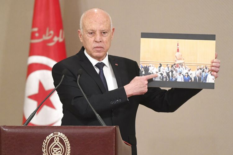 Dalam foto yang disebarluaskan oleh Kepresidenan Tunisia ini, Presiden Tunisia Kais Saied menunjukkan adegan bentrokan antara anggota parlemen di parlemen sebelumnya, saat upacara pelantikan pemerintahan baru, Senin, 11 Oktober 2021 di Tunisia. 