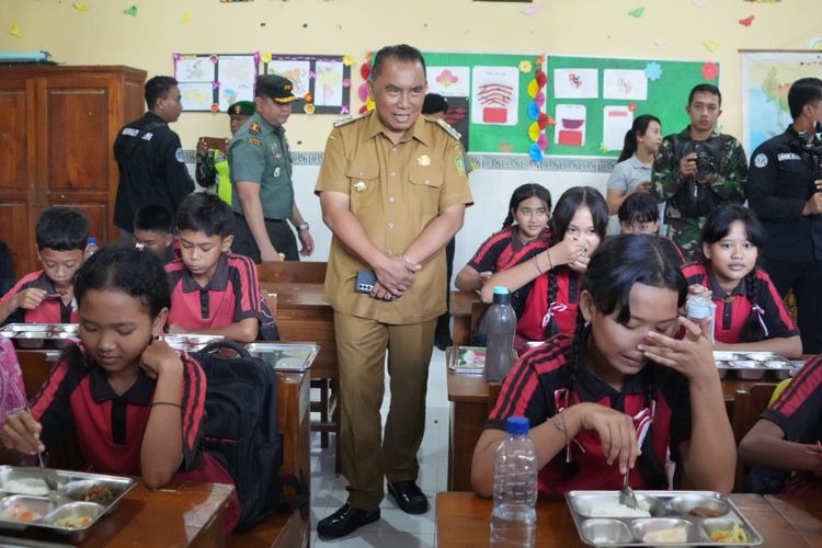 Bupati I Nengah Tamba saat memantau pendistribusian makanan program Makan Bergizi Gratis  tahap awal bersama Forum Koordinasi Pimpinan Daerah (Forkopimda) Jembrana SD 1 Banjar Tengah, Kecamatan Negara, Senin (6/1/2025). 