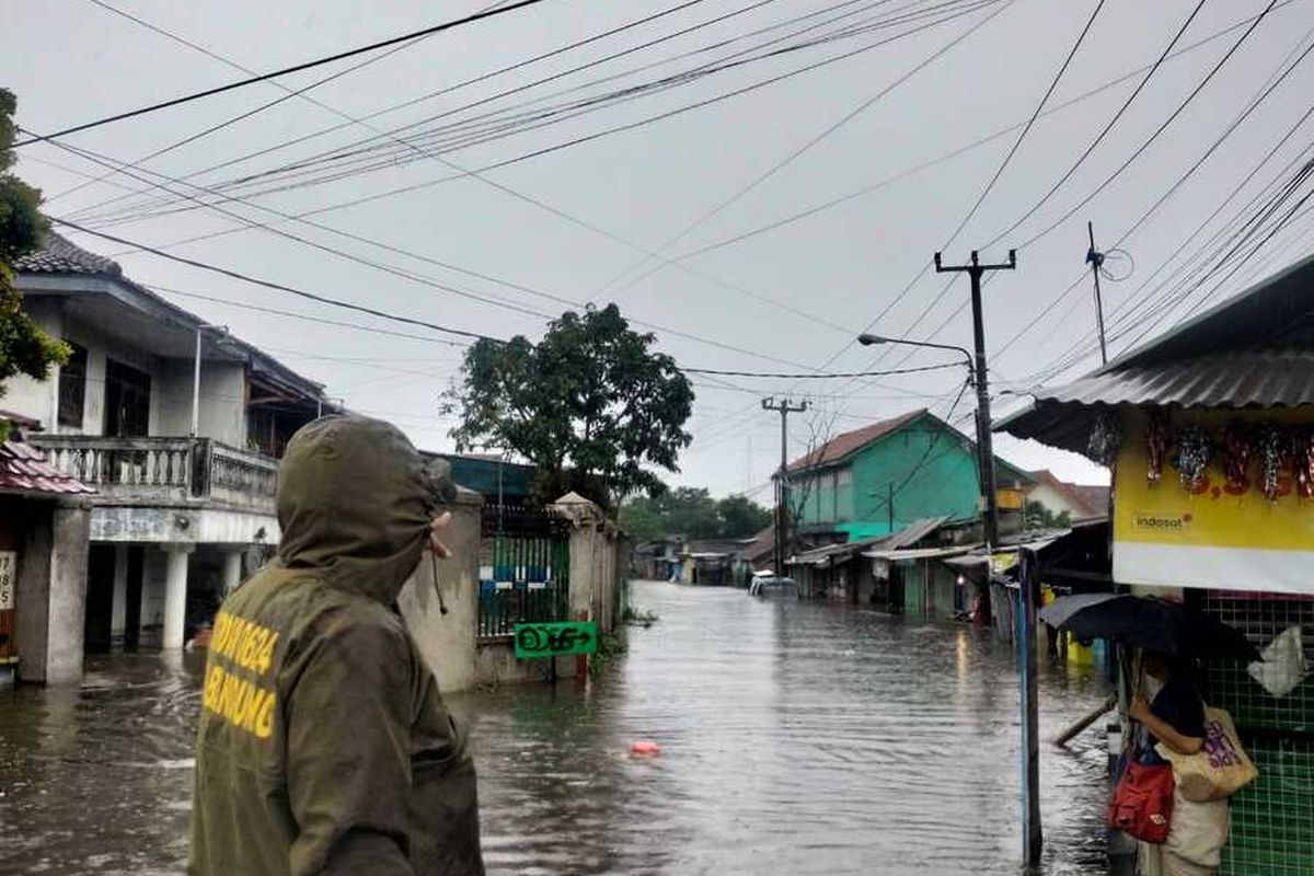Sejumlah petugas kepolisian tengah mengatur arus lalulintas di jalan raya Dayeuhkolot, Kabupaten Bandung, Jawa Barat, pada Jumat (25/2/2025) akibat dilanda banjir sejumlah ruas jalan menuju Kabupaten Bandung terputus.