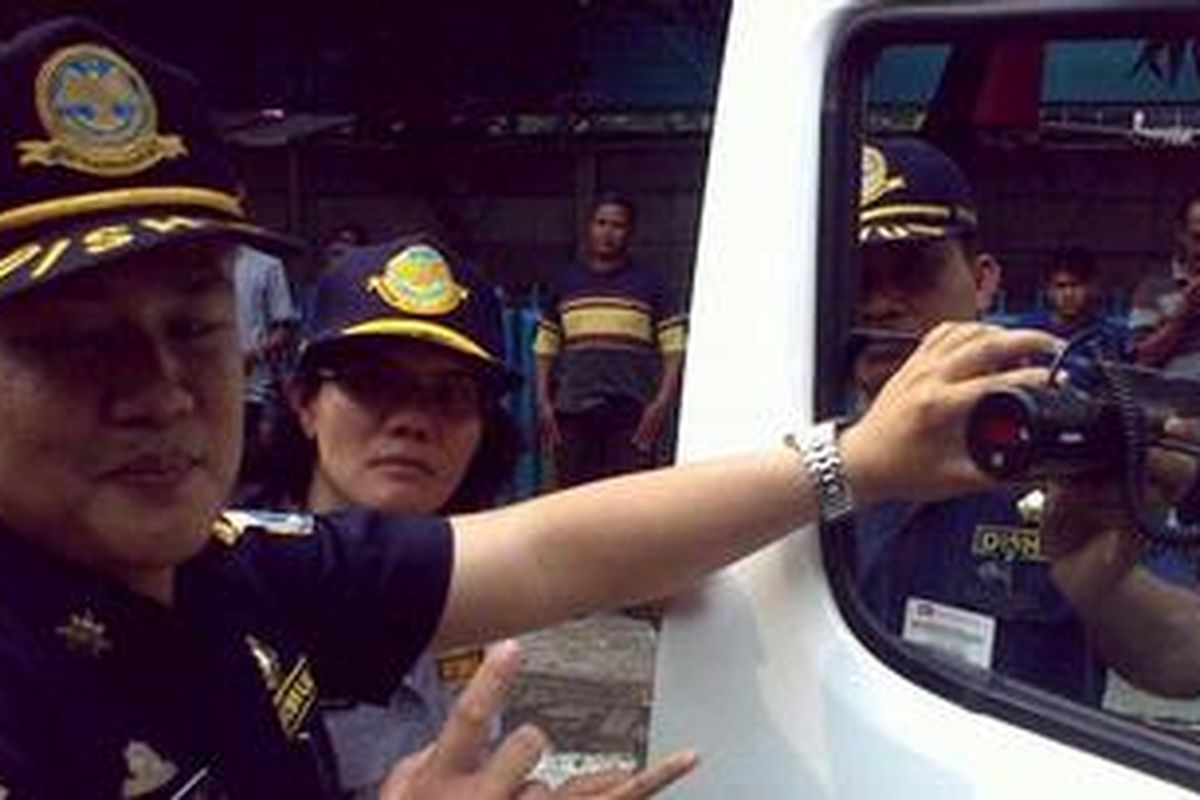 Salah seorang petugas Dinas Perhubungan (Dishub) DKI Jakarta memeriksa tingkat tembuh cahaya pada angkutan umum di Terminal Lebak Bulus, Minggu (18/9/2011).