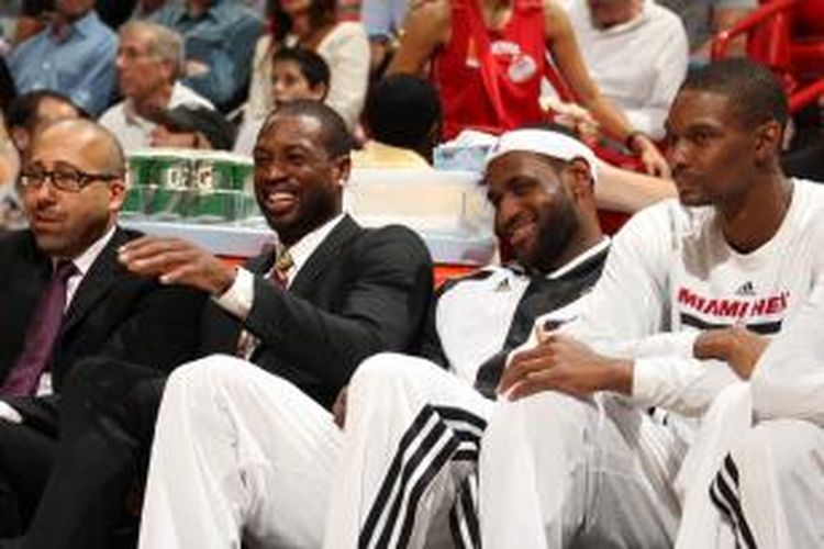 Pemain Miami Heat, Chris Bosh (kanan), LeBron James (dua dari kanan), dan Dwyane Wade (dua dari kiri) tertawa saat duduk di bangku cadangan, pada pertandingan lanjutan kompetisi NBA antara Heat dan Atlanta Hawks di American Airlines Arena, Selasa (19/11/2013).