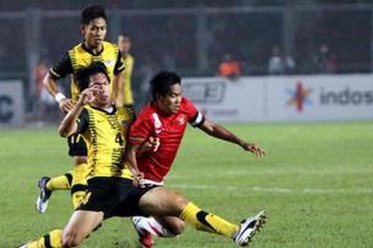 Pemain U23, Egi Melgiansyah (kanan), dijatuhkan pemain Malaysia, Mohd Shas Mohamad Fadhli, pada pertandingan final SEA Games XXVI di Stadion Gelora Bung Karno, Jakarta Pusat, Senin (21/11/2011). 