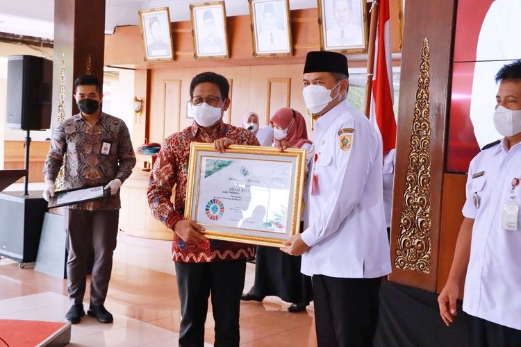 Menteri Desa PDTT Abdul Halim Iskandar menyerahkan piagam penghargaan kepada Bupati Wonogiri Joko Sutopo atas prestasinya sebagai sebagai daerah tercepat se-Indonesia dalam penyelesaian pendataan pemutakhiran data berbasis Suistanable Development Goals (SDGs) di Pendopo Kabupaten Wonogiri, Rabu (16/6/2021).