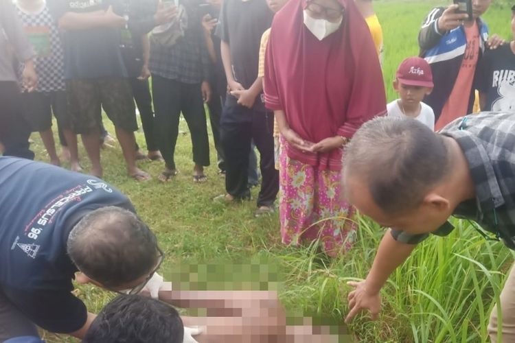 Polisi saat mengevakuasi mayat kakek 85 tahun yang ditemukan meninggal dunia di saluran irigasi sawah di Desa/Kecamatan Banjarharjo, Kabupaten Brebes, Jawa Tengah, Senin (16/5/2022) (Istimewa)