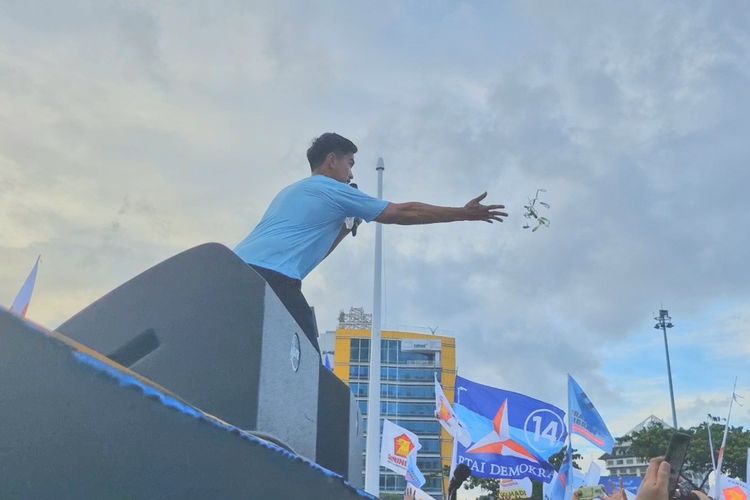 Ketua Umum Partai Solidaritas Indonesia (PSI) Kaesang Pangarep membagikan gantungan kunci belimbing sayur kepada massa kampanye di Simpang Lima Semarang, Minggu (28/1/2024).