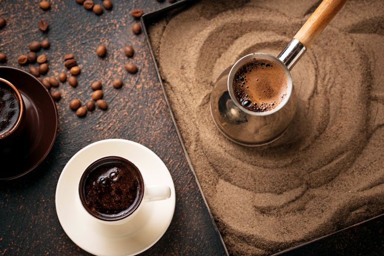 Ilustrasi kopi turki yang dimasak di atas pasir.