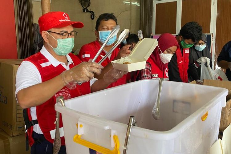 Indonesian Red Cross (PMI) Secretary-General Sudirman Said gives aid to people displaced by the Jakarta floods in East Jakarta municipality on Saturday, (20/2/2021)