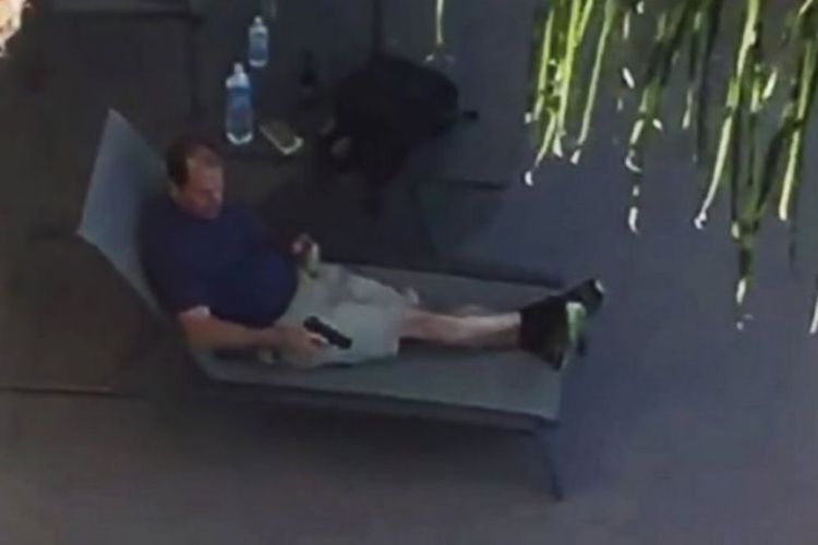 Tersangka pelaku penembakan di San Diego, Peter Selis (49) duduk santai di tepi kolam sambil memegang sepucuk pistol.