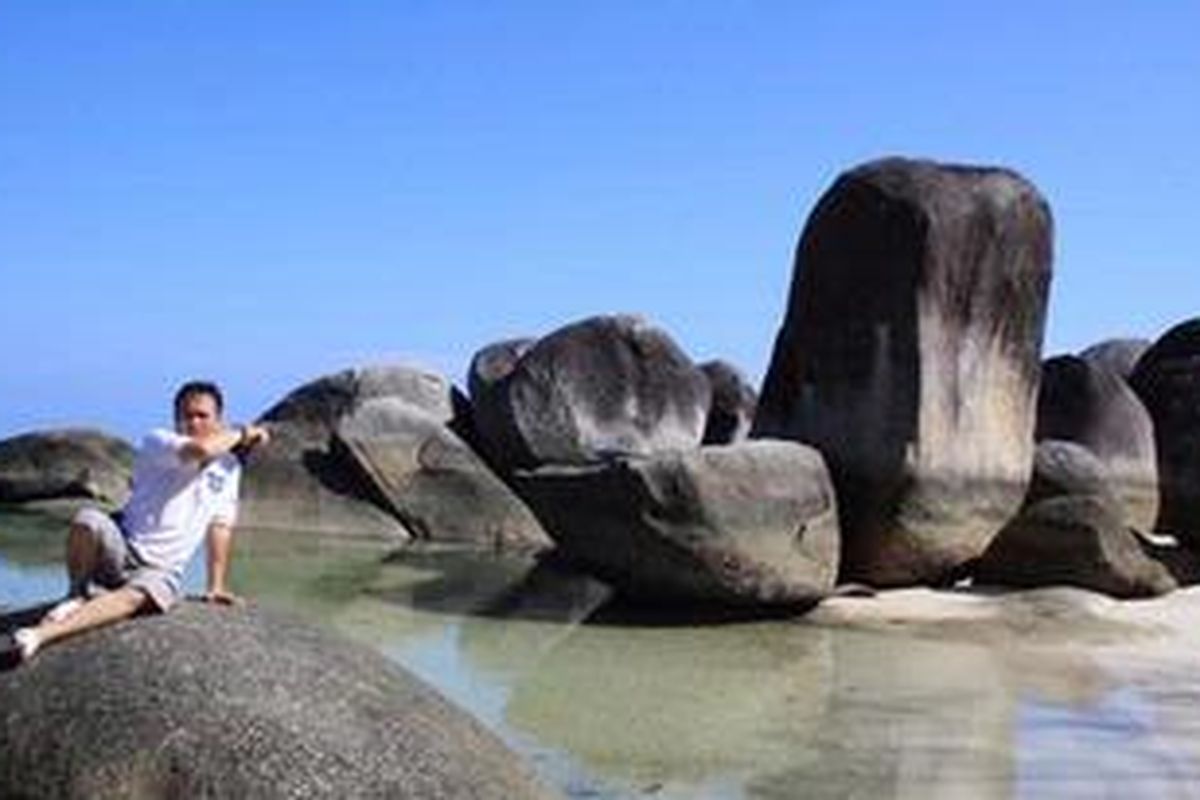 Seorang wisatawan tengah asyik bersantai di Pantai Tanjung Tinggi, Belitung.
