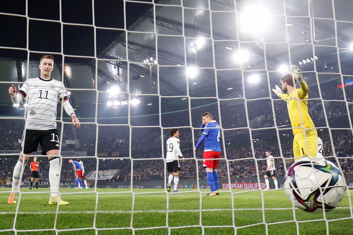 Pemain depan Jerman, Marco Reus (kiri), membobol gawang Liechtenstein yang dikawal kiper Benjamin Buechel (kanan), dalam pertandingan penyisihan Grup J Piala Dunia Qatar 2022 di Wolfsburg, Jerman, 11 November 2021.