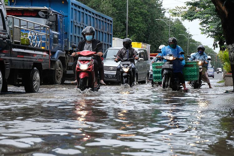 Sejumlah kendaraan melintasi genangan air saat banjir di jalur Pantura kota Kendal, Jawa Tengah, Senin (8/2/2021). Sejak dua hari lalu jalur Pantura di kota Kendal tergenang air sehingga mengakibatkan lalu lintas tersendat, selain itu banjir juga menggenangi puluhan desa di kabupaten Kendal.