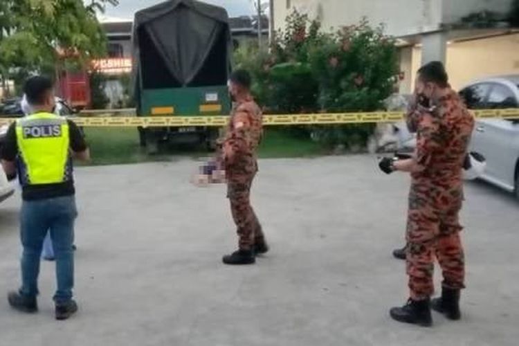 Polisi yang berkumpul di dekat jasad seorang pria 26 tahun yang jatuh dari lantai 10 di sebuah apartemen di Penang, Malaysia, pada Rabu (23/6/2021). [AITO Firework/FB Via World of Buzz]