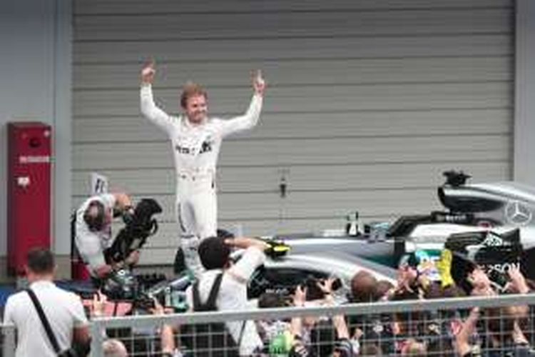 Pebalap Mercedes AMG Petronas asal Jerman, Nico Rosberg, merayakan kemenangan setelah finis di urutan pertama pada balapan GP Jepang di Sirkuit Suzuka, Minggu (9/10/2016).