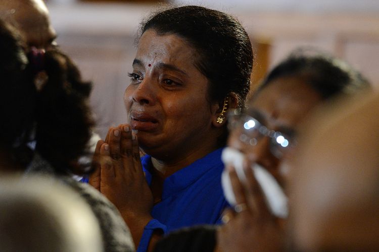 Seorang kerabat korban serangan Minggu Paskah bereaksi saat berdoa dalam kebaktian yang dihadiri oleh para penyintas pada kesempatan pembukaan kembali gereja St Anthony di Kolombo pada 12 Juni 2019. Gereja Katolik yang dibom di Sri Lanka dikonsekrasikan kembali pada 12 Juni dengan sebuah doa bagi pemimpin nasional yang kuat untuk menghukum mereka yang bertanggung jawab atas serangan Paskah yang menewaskan 258.