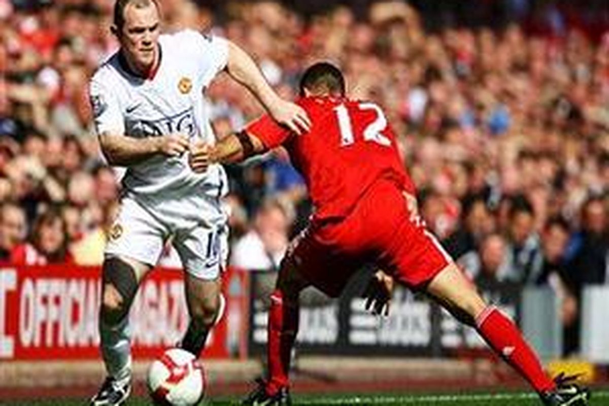 Striker MU, Wayne Rooney (kiri), mencoba melewati pemain Liverpool, Fabio Aurelio. Rooney gagal mencetak gol dan MU akhirnya kalah 1-2 dari Liverpool