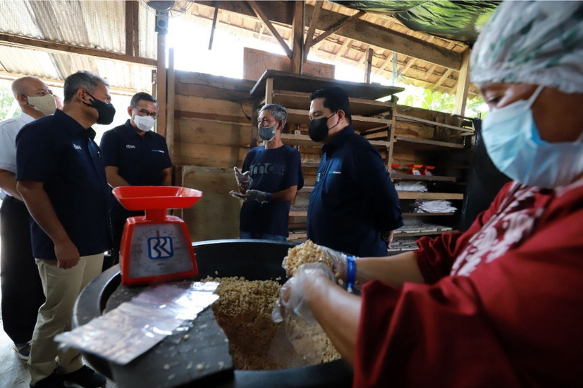 Direktur Utama BRI Sunarso (kiri) bersama Menteri BUMN Erick Thohir (kanan) saat mengunjungi sentra produksi tempe di Kebun Jeruk, Kelurahan Saung Naga, Kecamatan Baturaja Barat.