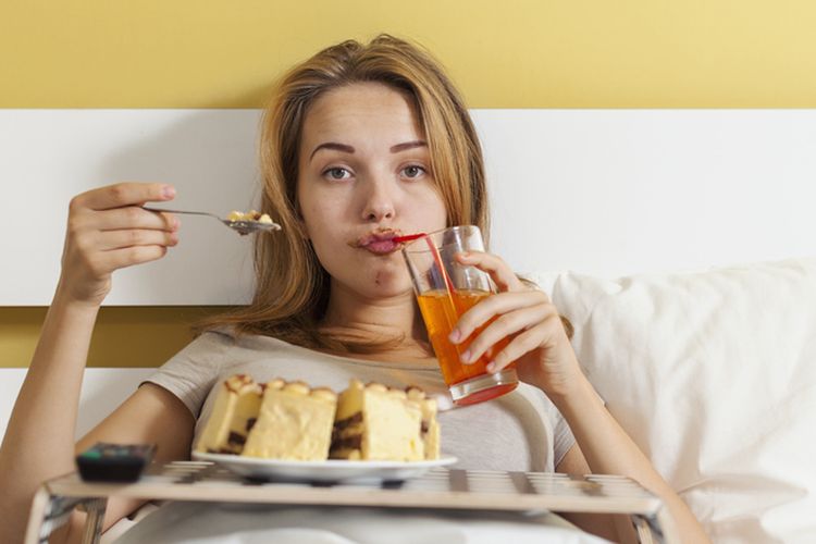 Ilustrasi makan di tempat tidur. Kebiasaan makan di tempat tidur bisa menjadi penyebab munculnya semut. 