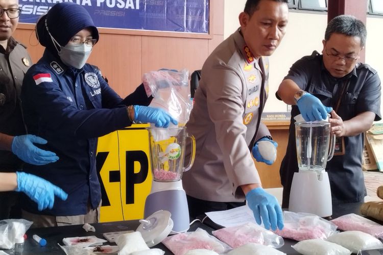 Anggota Puslabfor Fitryana (kiri) dan Kapolres Metro Jakarta Pusat Kombes Komarudin (kanan) memasukkan barang bukti narkoba ke blender untuk dimusnahkan di Mapolres Metro Jakarta Pusat, Selasa (6/6/2023).
