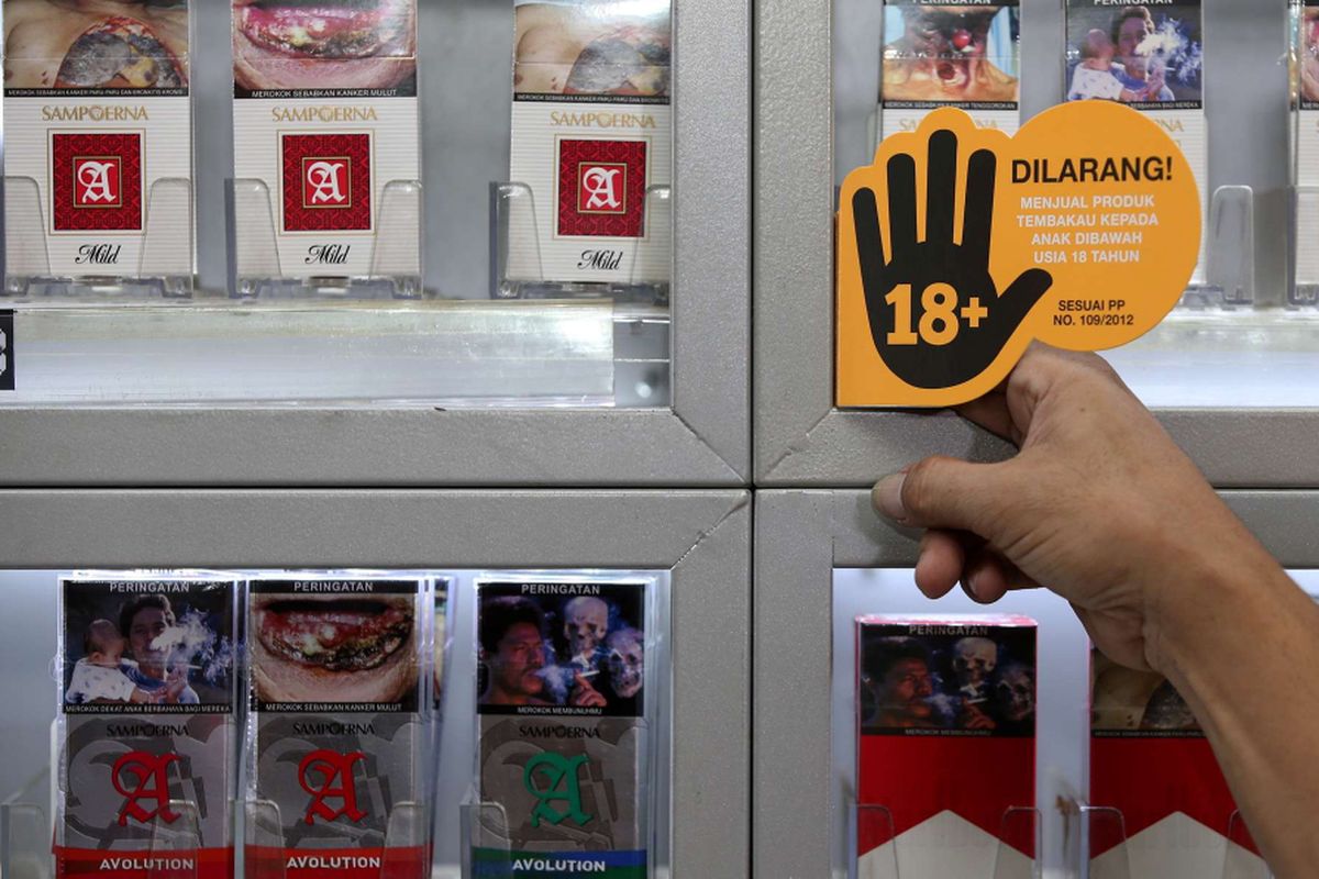 Penjual anggota Komunitas Ritel Sampoerna menunjukan stiker Program Pencegahan Akses Pembelian Rokok oleh Anak-anak (PAPRA) di bawah usia 18 tahun di Toko Mm - Qia di Cipete, Jakarta Selatan, Kamis (14/12/2017). 