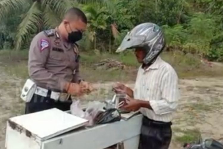 Tangkapan layar video saat Bripka Donni Malindo memborong es tong tong milik seorang pria yang terjaring razia lalu lintas di Kecamatan Lirik, Kabupaten Inhu, Riau, beberapa hari lalu.
