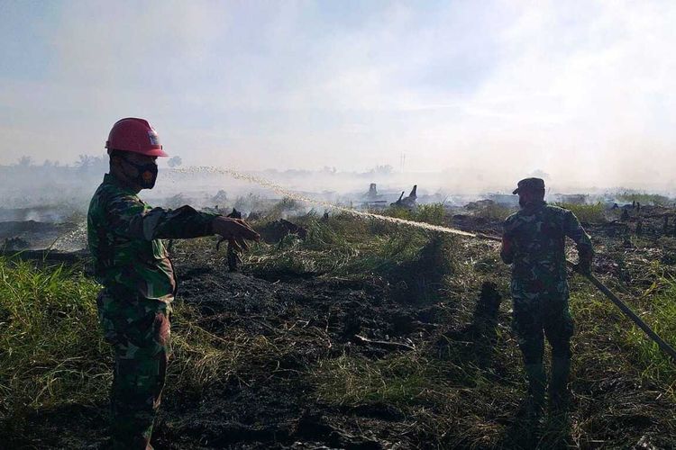 Petugas TNI dan kepolisian tengah melakukan pemadaman api karhutla di Desa Bonai, Kecamatan Bonai Darussalam, Rohul, Riau, Kamis (29/7/2021).