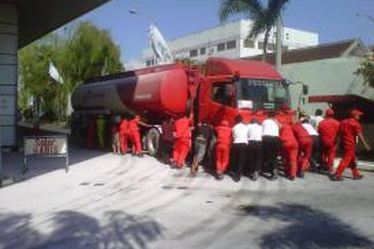 Usai dipadamkan, Karyawan SPBU Ahmad Yani Jember Jawa Timur, mendorong mobil keluar dari area SPBU, Jumat (20/9/13)