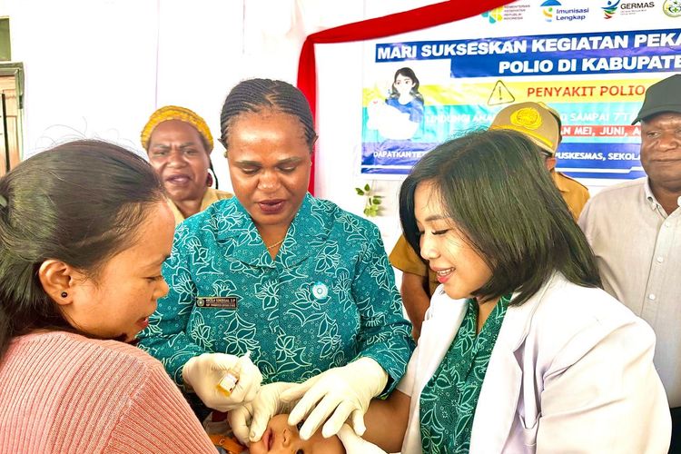 Ketua TP PKK Kabupaten Intan Jaya, Ancela Sondegau (tengah) saat memberikan imunisasi polio secara simbolis kepada seorang balita (27/5/2024).